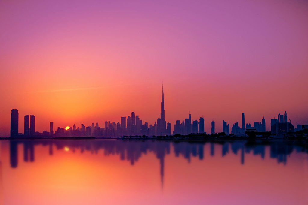Skyline of a Middle Eastern city at sunset.