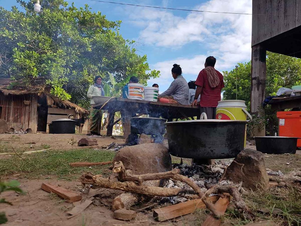 Image of a family cooking over a firepit.