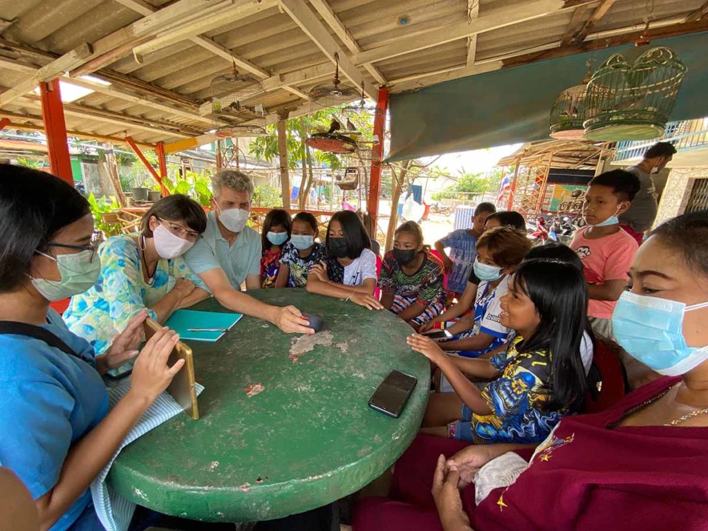 Two IWs presenting on a tablet to a group of Southern Thai.
